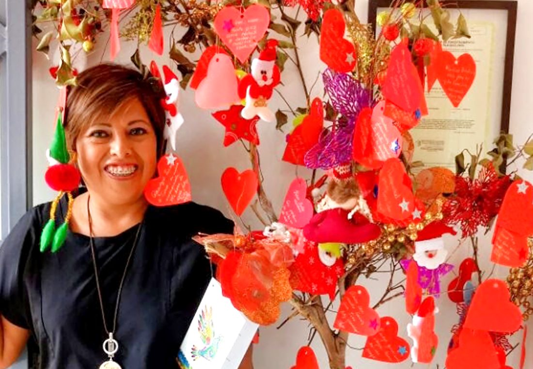 Tina en el salón, junto al árbol de corazones escritos por las clientas